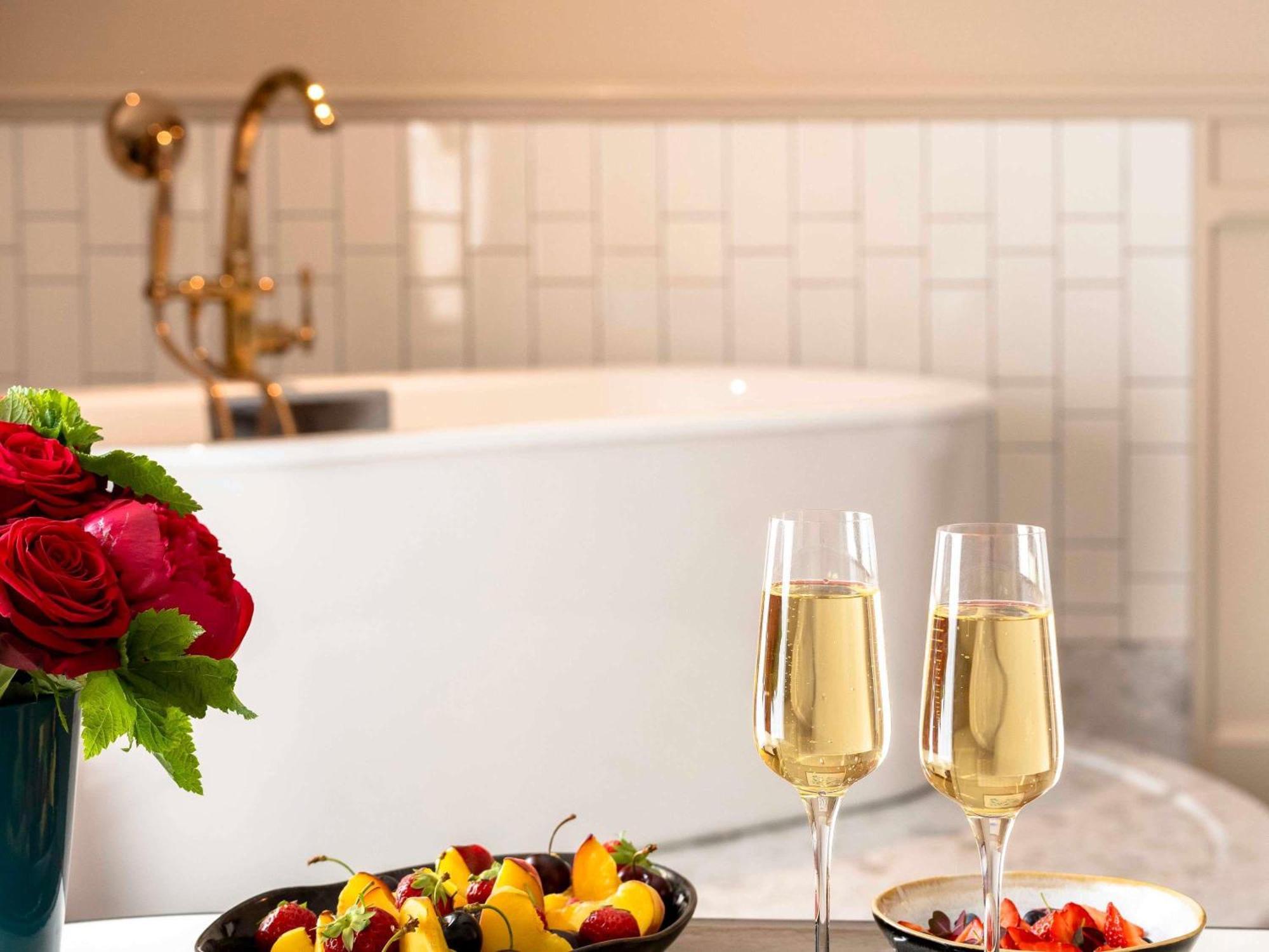 Suite Luna de Miel con cama redonda, bañera, zona de salón y vistas al Grand Boulevard