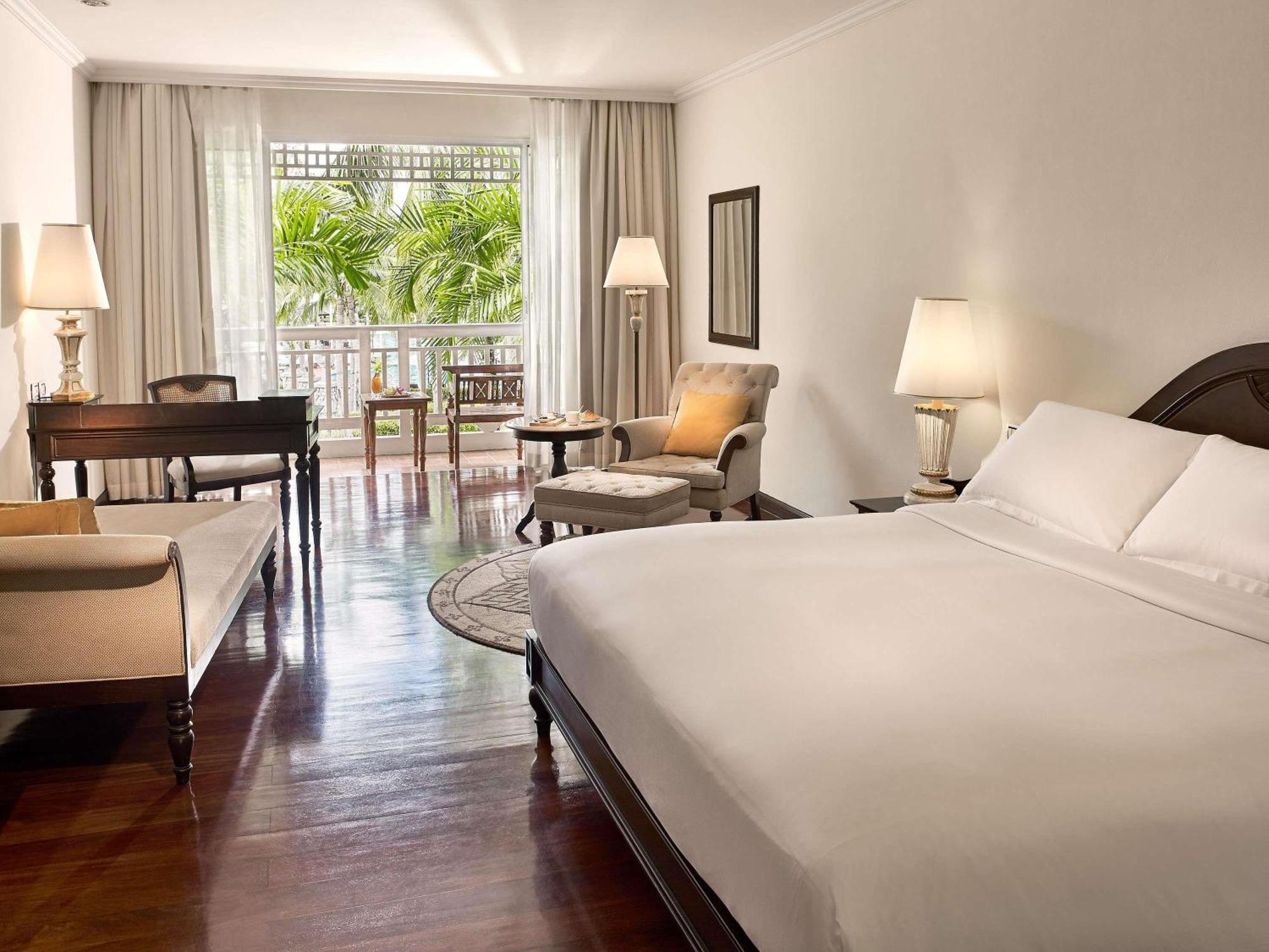 Luxuriöses Zimmer mit Kingsize-Bett sowie Pool- und Gartenblick